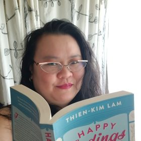 Thien-Kim Lam holding a copy of Happy Endings